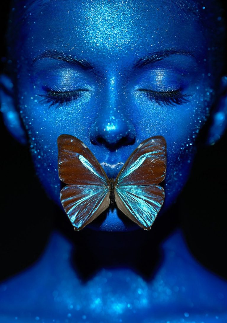 Persona con el rostro parcialmente cubierto por una mariposa, simbolizando la calma, introspección y transformación que aporta el silencio.