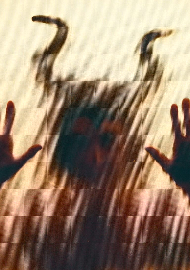 Persona con el rostro parcialmente cubierto por una mariposa, simbolizando la calma, introspección y transformación que aporta el silencio.